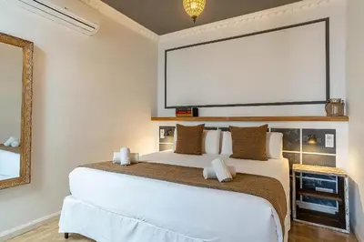 a bedroom with a white bed with a large screen at Casa Gracia Apartments in Barcelona