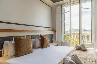 a bedroom with a bed with a large window at Casa Gracia Apartments in Barcelona