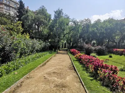 a dirt path through a garden with flowers at ApartEasy - Turo Park with lovely balcony in Barcelona