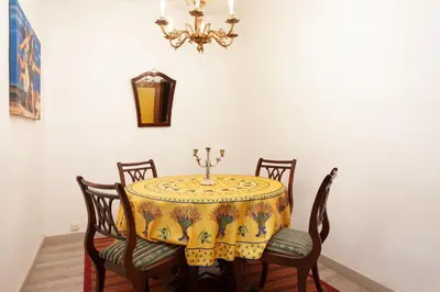 a dining room with a table with chairs and a chandelier at Esquirol in Barcelona