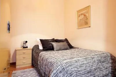 a small bedroom with a bed and a dresser at Esquirol in Barcelona