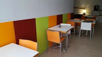 a restaurant with colorful walls and tables and chairs at Hostal Aslyp 114 in Barcelona