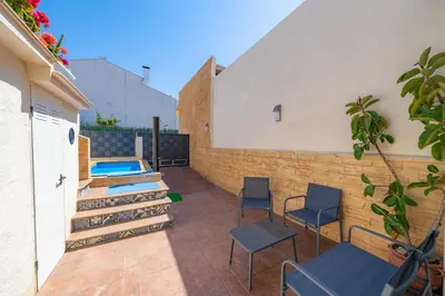 a patio with chairs and a swimming pool at HomeHolidaysRentals Benoit - Costa Barcelona in Pineda de Mar
