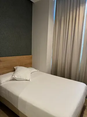 a bedroom with a white bed and a window at Fontanella By BCN URBAN Rooms in Barcelona