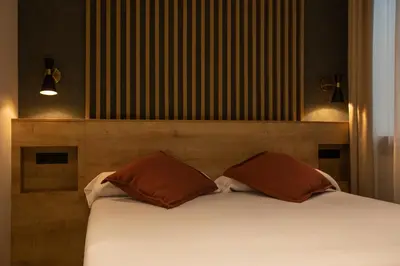 a bed with two brown pillows in a room at Fontanella By BCN URBAN Rooms in Barcelona