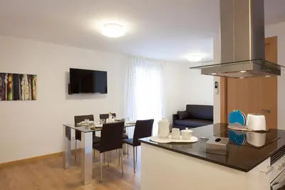 a kitchen and living room with a table and a kitchen and a dining room at Casa Codina in Barcelona