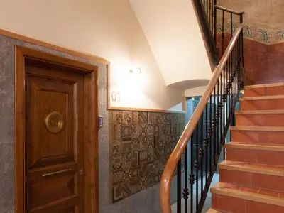 a hallway with a wooden door and stairs at Casa Codina in Barcelona