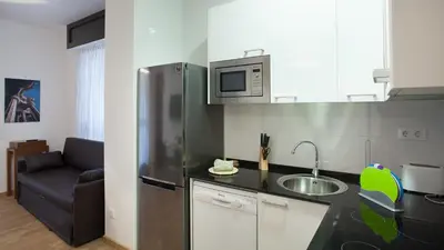 a kitchen with a stainless steel refrigerator and a sink at Casa Codina in Barcelona
