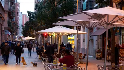 a group of people walking down a street with umbrellas at Casa Codina in Barcelona