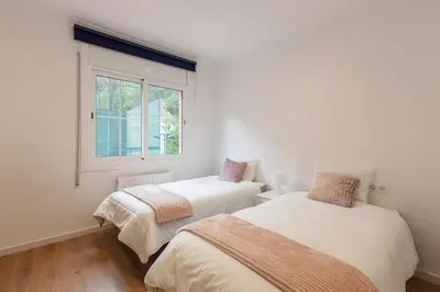 two beds in a white room with a window at L'aviador de Can Ton in Sant Llorenc Savall
