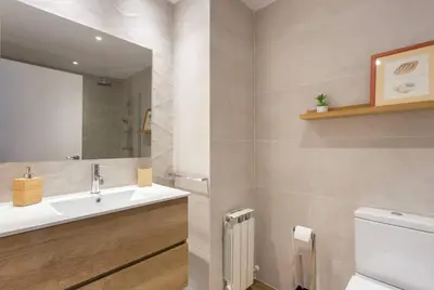 a bathroom with a sink and a mirror and a toilet at New Apartment With Private Rooftop in Hospitalet de Llobregat