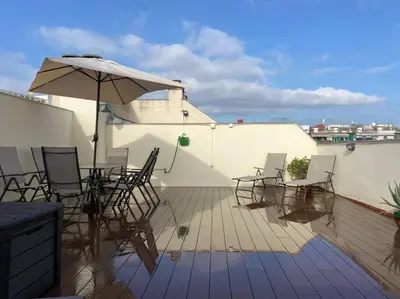 a patio with chairs and an umbrella on a roof at New Apartment With Private Rooftop in Hospitalet de Llobregat