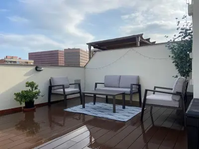 a patio with two chairs and a table on a roof at New Apartment With Private Rooftop in Hospitalet de Llobregat