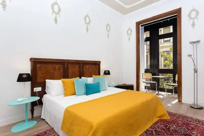 a bedroom with a large bed with a yellow blanket at Luxury 4bdr In Gracia in Barcelona
