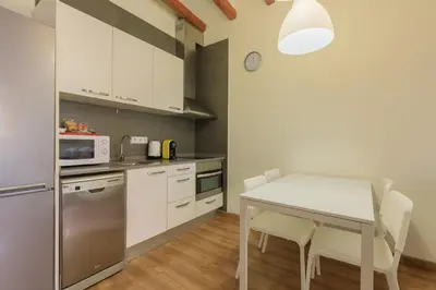 a kitchen with a white table and a microwave at Housalia Gracia in Barcelona