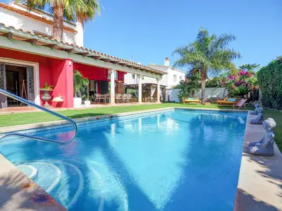 a swimming pool with a hose in front of a house at Villa Nirvana by Hello Homes Sitges in Sitges