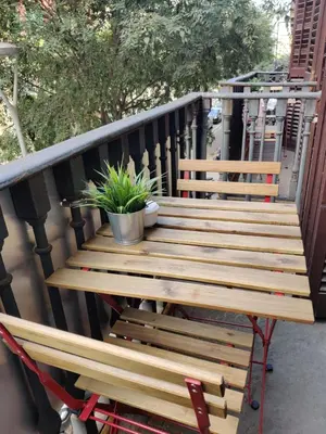 a wooden bench on a balcony with a plant at Hostal Live Natura Barcelona in Barcelona