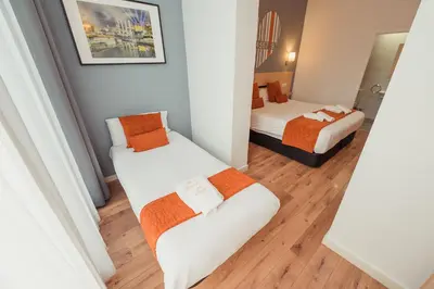 a room with two beds and a mirror at Hostal Live Natura Barcelona in Barcelona