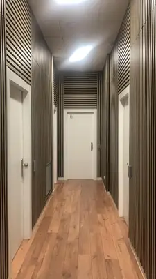 an empty hallway with a white door and wooden floors at Hostal Live Natura Barcelona in Barcelona
