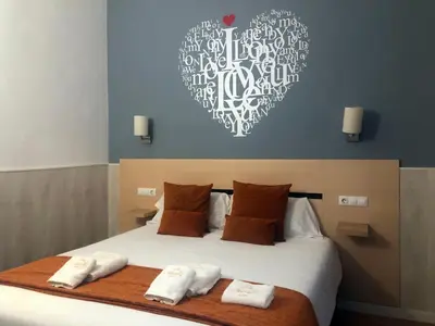 a bedroom with a large bed with towels on it at Hostal Live Natura Barcelona in Barcelona