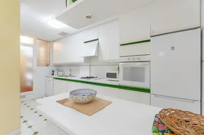 a kitchen with white cabinets and a bowl on the floor at ESTRELLA DE MAR Sitges in Sitges