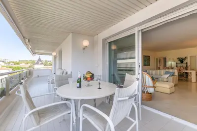 a white table and chairs on the balcony of a house at ESTRELLA DE MAR Sitges in Sitges