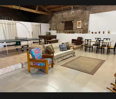 a living room with a ping pong table and chairs at Masia La Bomba in Masnou