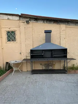 a grill sitting in front of a building at Masia La Bomba in Masnou