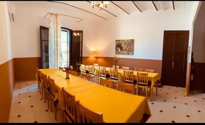 a large dining room with yellow tables and chairs at Masia La Bomba in Masnou