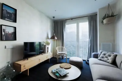 a living room with a television and a couch and a table at SONORA - Bright Apartment with view of Sagrada Familia in Barcelona