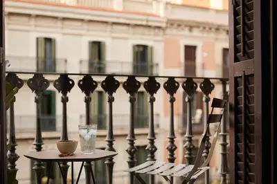 a chair and a glass on a table on a balcony at DENALI - Stylish apartment in center of Barcelona in Barcelona