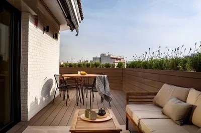 a rocking chair sitting on a deck on a balcony at DOURO - Penthouse with a view of the Sagrada F. in Barcelona