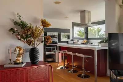 a kitchen with a counter with stools and a vase with flowers at 4 BR vila 25 minutes to Barcelona Fantastic sea views pool in Alella