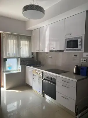 a kitchen with white cabinets and a stove top oven at BADAROSA House Badalona next to Barcelona & beach in Badalona