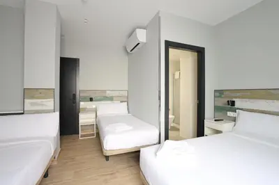 a room with two beds and a mirror at Hey Rooms in Cerdanyola del Valles