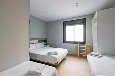 a bedroom with two beds and a window at Hey Rooms in Cerdanyola del Valles