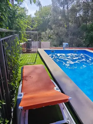 a swimming pool with an orange bench next to it at Relax House Barcelone in Sant Esteve Sesrovires