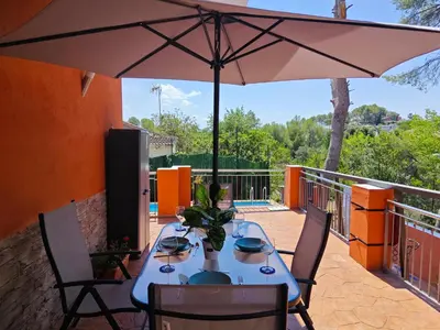 a table with an umbrella on a patio at Relax House Barcelone in Sant Esteve Sesrovires