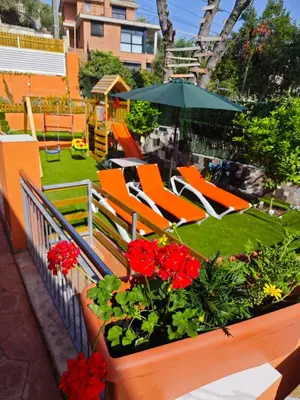 a patio with chairs and flowers and an umbrella at Relax House Barcelone in Sant Esteve Sesrovires