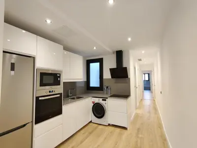 a kitchen with white cabinets and a washer and dryer at Stylish apartments Camp Nou in Hospitalet de Llobregat
