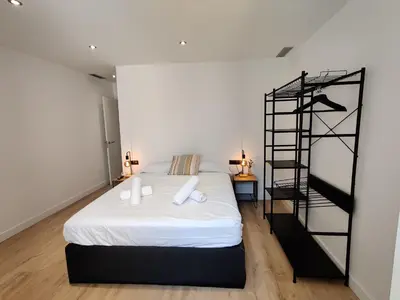 a bedroom with a white bed and a spiral staircase at Stylish apartments Camp Nou in Hospitalet de Llobregat