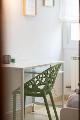 a desk with a green chair in a room at Apartamento con gran patio y excelente ubicación! in Mataró