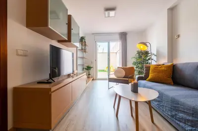 a living room with a blue couch and a tv at Apartamento con gran patio y excelente ubicación! in Mataró