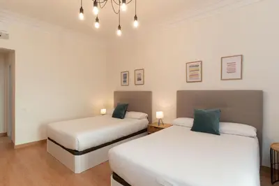 two beds in a room with white walls at SibsBcn-Paseo de Gracia Luxury Exclusive Gaudí in Barcelona