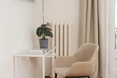 a chair sitting next to a table with a potted plant at SibsBcn-Paseo de Gracia Luxury Exclusive Gaudí in Barcelona