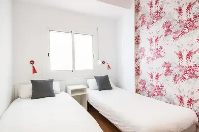 two beds in a room with white walls at Apartment with terrace a step away from Montjuic, Barcelona in Barcelona