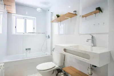 a white bathroom with a sink and a toilet at Apartment with terrace a step away from Montjuic, Barcelona in Barcelona