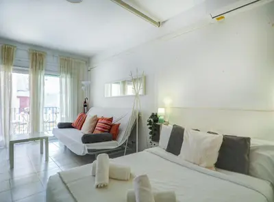 a living room with a bed and a couch at Ferdinand Apartment by Hello Homes Sitges in Sitges