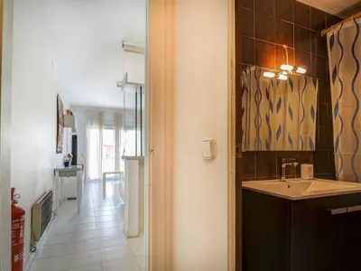 a small kitchen with a sink and a hallway at Ferdinand Apartment by Hello Homes Sitges in Sitges