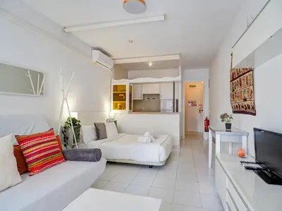 a living room with a white couch and a tv at Ferdinand Apartment by Hello Homes Sitges in Sitges